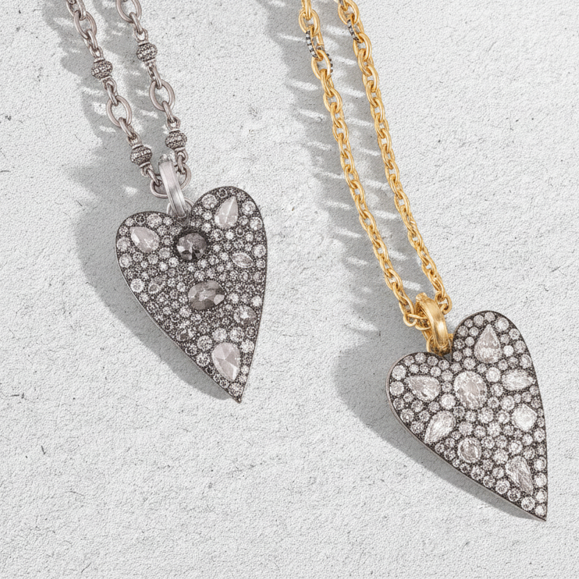 Two heart-shaped pendants on gold and silver chains against a light gray background